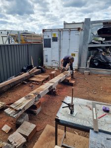 Removing hundreds of corroded nails and bolts from the timber ahead of machining